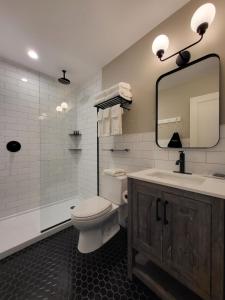 The Stowe Village Inn في ستو: حمام مع مرحاض ومغسلة ومرآة