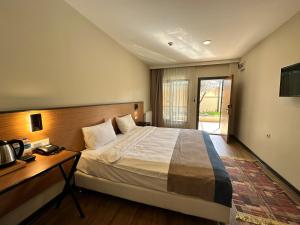 a bedroom with a bed and a desk and a television at N'Ala Otel in Sakarya
