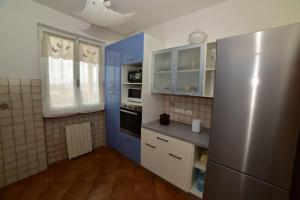 a kitchen with blue and white cabinets and a refrigerator at Casa vacanze il Pastore Tedesco in Portoferraio