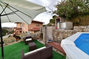 a patio with an umbrella and a swimming pool at Casa vacanze il Pastore Tedesco in Portoferraio