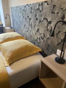 a bedroom with a bed with a floral wall at Ginkobiloba : Appartement cosy en cœur de ville in Bagnères-de-Bigorre