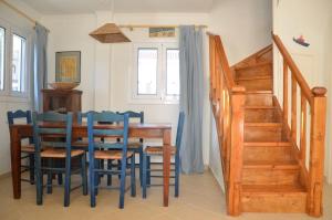 a dining room with a wooden table and blue chairs at L'Olivetta in Lithakia +9 photos
