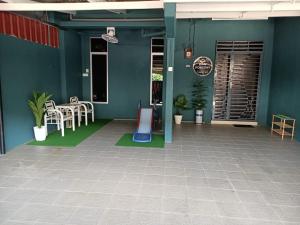 a building with a patio with a table and chairs at RIANI HOMESTAY in Kertih