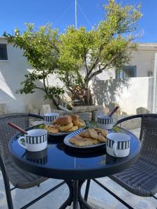 uma mesa azul com pratos de comida em Orphanos House em Kamilárion