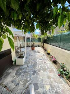 a stone walkway with plants and a fence at La Casa di Betty in Lido di Ostia