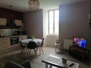 een woonkamer met een tafel en een keuken bij La pause in Saint-Agrève