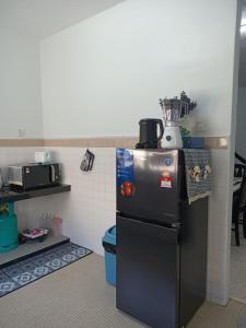 a kitchen with a black refrigerator in a room at RIANI HOMESTAY in Kertih