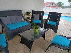 a patio with wicker chairs and a table and a pool at Les 2 Chambres Wassai in Rémiré +4 photos
