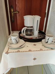 a coffee maker and two cups on a table at Chambre Wassai in Rémiré
