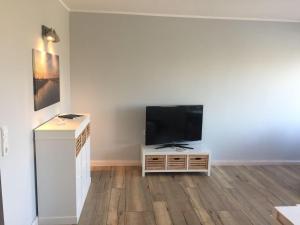 a living room with a flat screen tv on a white cabinet at derankerplatz-fehmarn in Burgtiefe auf Fehmarn 