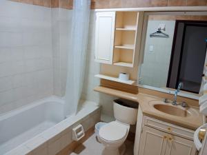 y baño con aseo, lavabo y bañera. en Luna Azul Rodadero apartaestudios en Santa Marta