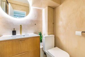 a bathroom with a toilet and a sink and a mirror at GuestReady - Wabi-Sabi Minimal in Marais in Paris