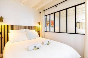 a bedroom with a white bed with two towels on it at GuestReady - Wabi-Sabi Minimal in Marais in Paris