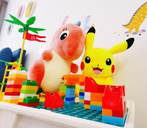 einem Spielzeugpikachu und anderen Spielzeugen auf einem Regal in der Unterkunft Legoland - HappyWonder Suite for Family ,Cozy, Wifi with Nice Garden Pool View! in Nusajaya