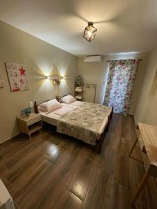 a bedroom with a large bed and a wooden floor at Villa Rafailia in Olympiaki Akti