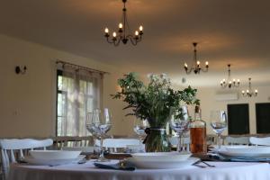 a table with wine glasses and a vase with flowers at Zöld Tanya Vendégház és Rendezvényközpont in Kiskunmajsa