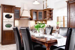 a dining room with a wooden table and black chairs at Constantia by Grape Hotel in Wrocław