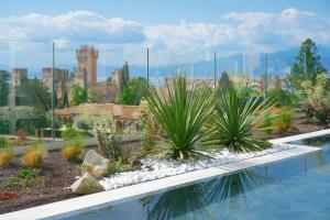 una piscina con plantas en un jardín en Palazzo della Scala Spa Hotel Suites & Apartments, en Lazise