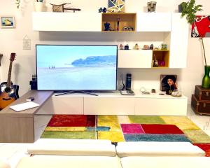 un soggiorno con una grande TV a schermo piatto su una scrivania di Casa mare Golfo di Cagliari a Su Forti