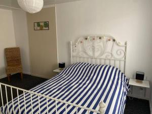 a bedroom with a blue and white striped bed at L'étape Champenoise in Ay