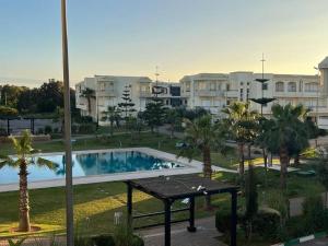 a view of a swimming pool in a resort at Superbe Appartement Bord de mer in Bouznika