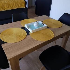 a wooden table with four yellow plates on it at studio avec terrasse au calme in Jayat +5 photos