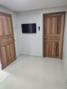 an empty room with two doors and a television at JR Casa Contêiners in Boa Vista