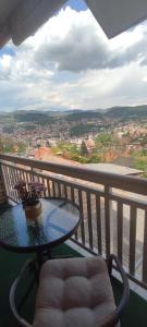 a table and chair on a balcony with a view at Holiday Home Old Town in Sarajevo