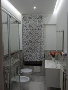 een badkamer met een toilet, 2 wastafels en een douche bij Andrea Accomodation in Tropea