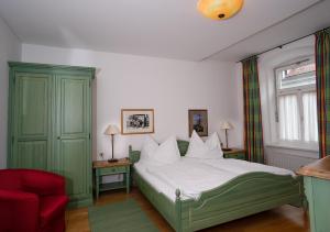 um quarto com uma cama e uma cadeira vermelha em Gasthof zum Greif em Leoben