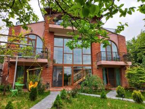 a brick house with large windows at Hestia - Hotel, Wine and View in Tʼelavi