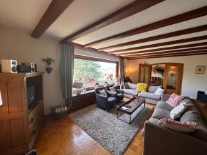 a living room with couches and a large window at Private Spacious Villa near Winterberg and Willingen 14 Guests HUGE GARDEN Free Parking for Multiple Cars in Olsberg