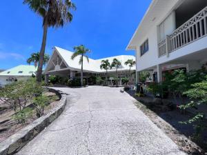 uma passagem em frente a um edifício com palmeiras em Studio Tortola Orient Bay VUE MER em São Martinho