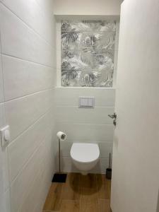La salle de bains est pourvue de toilettes blanches et de papier peint. dans l'établissement Blue ocean, à Biscarrosse