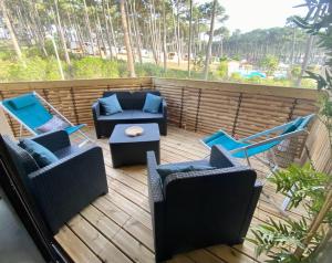 eine Terrasse mit Sofas, Stühlen und einem Tisch in der Unterkunft Blue ocean in Biscarrosse