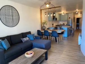 Blue ocean في بيسكاروس: غرفة معيشة مع أريكة زرقاء ومطبخ