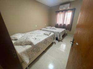 Giường trong phòng chung tại Casa geminada privativa com 2 quartos, cozinha e sala - sob nova direção, veja nota mas reserve o novo