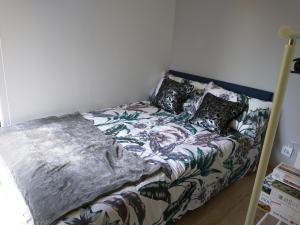 Una cama con una manta y almohadas encima en Kwiat Jabłonki, en Wikno
