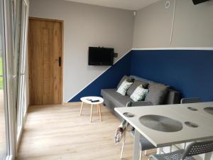 una sala de estar con un sofá y una mesa en Kwiat Jabłonki, en Wikno
