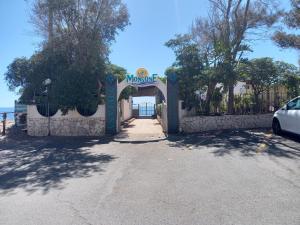 ein Tor zu einem Haus mit einem Schild, das Monaroe liest in der Unterkunft Blu Corallo in Mascali