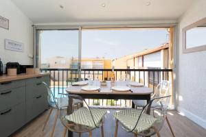een tafel en stoelen in een keuken met een balkon bij Appartement 5 personnes vue mer in Cap d'Agde