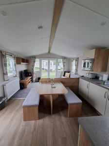 a kitchen with a table and benches in a room at Holiday Home at Cherry Tree Holiday Park 738 in Great Yarmouth