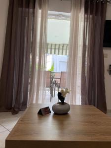 佩科霍里的住宿－Bella Maisonette，一张木桌,上面有花瓶
