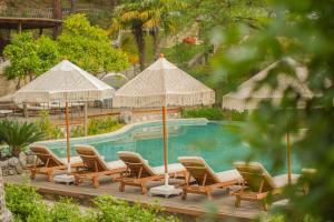 Eine Gruppe von Stühlen und Sonnenschirmen neben einem Pool in der Unterkunft Nuup Hotel in Marmaris