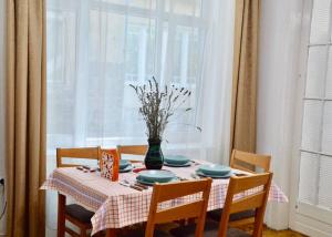 una mesa de comedor con un jarrón de flores. en Family Home en Budapest