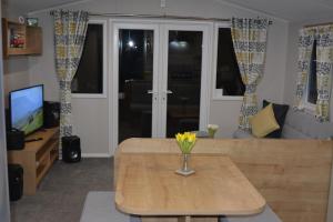 a living room with a vase of flowers on a table at Holiday Home at Cherry Tree Holiday Park 738 in Great Yarmouth