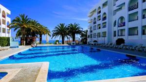 a swimming pool with palm trees and a building at Linda Vista Mar T1, A-C, Wi-Fi, Porches in Porches +56 photos