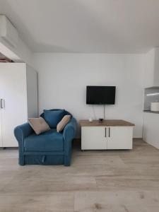 a living room with a blue couch and a tv at Budva Gate in Budva