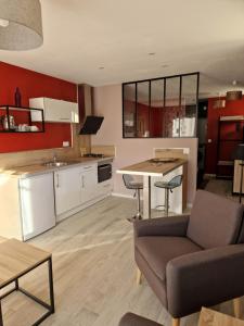 a kitchen and living room with a table and a couch at STUDIO 2 chez Fred et Val in Embrun