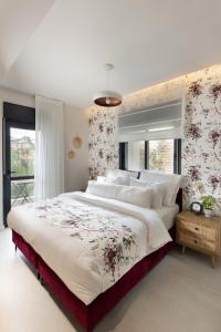 Talbiye brand new luxury place في القدس: غرفة نوم بسرير كبير وبجدار ورد